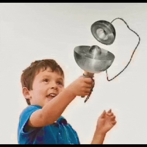 Ein Kind das eine abgewandelte Form des „Ball in den Becher“ Spiels in der Hand hält. Ball und Becher sind allerdings der „Demon Core“, eine Plutonium Sphäre